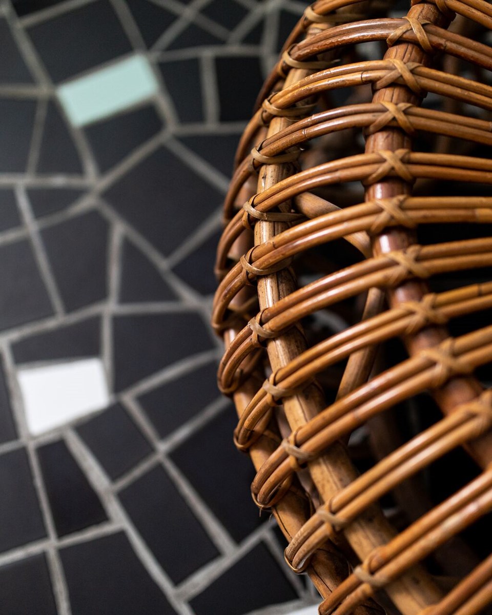 Close-up view of a rattan coffee table designed by India Mahdavi in one of the rooms of the hotel Le Cloître in Arles