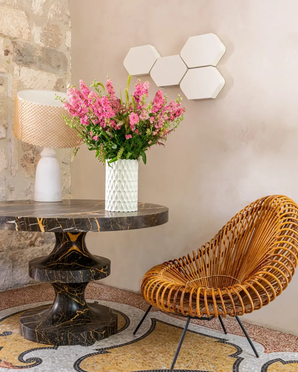 Fauteuil et table dans le lounge de l'hôtel Le Cloître à Arles